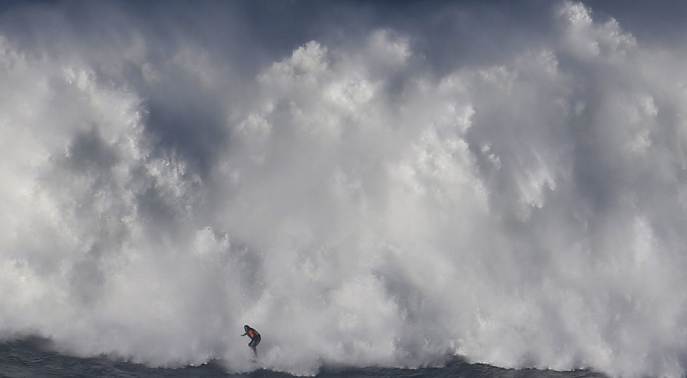 A surfer drops in on a large wave at Praia do Norte, in Nazare December 11, 2014. Praia do Norte beach has gained popularity with big wave surfers since Hawaiian surfer Garrett McNamara broke a world record for the largest wave surfed here in 2011. REUTERS/Rafael Marchante (PORTUGAL - Tags: SPORT ENVIRONMENT) - RTR4HOKK