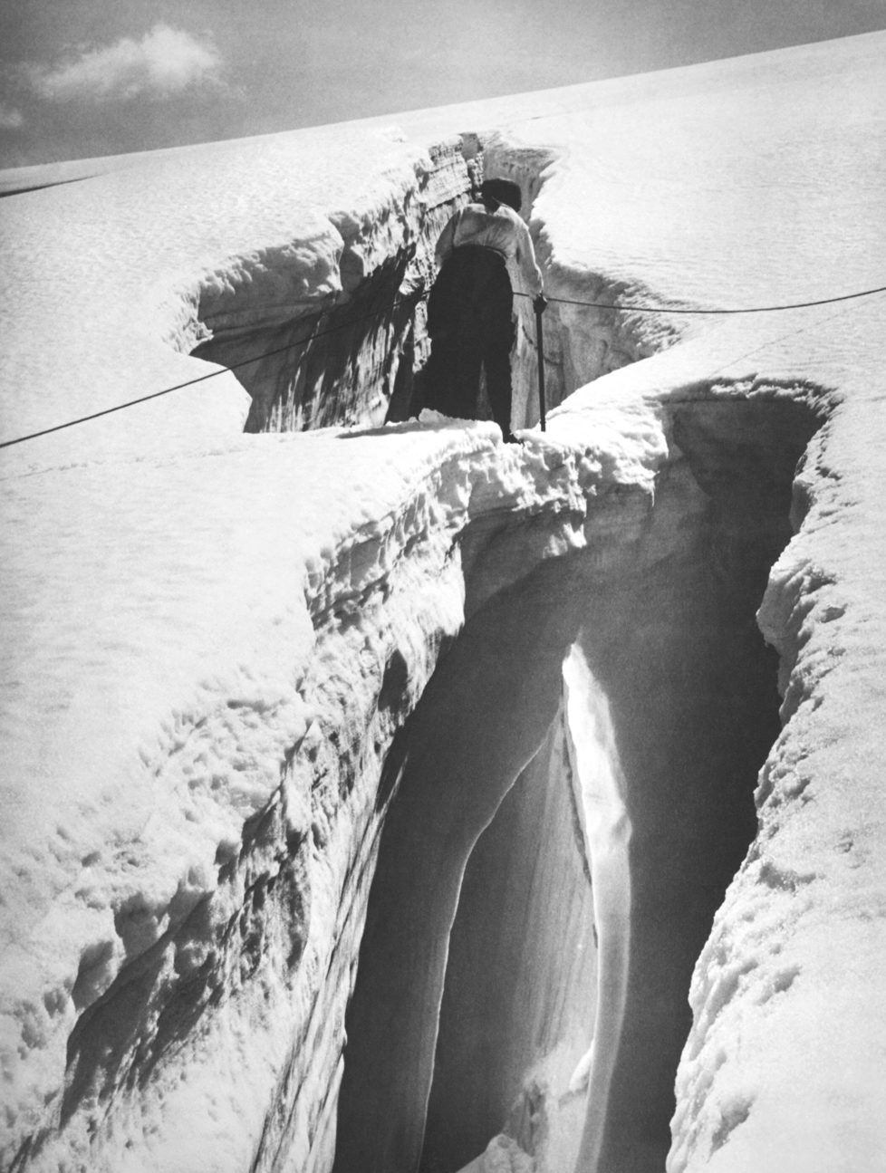 A mountain climber in the Swiss Alps cautiously traverses an ice bridge over a crevasse, Switzerland, circa 1928. (Photo by Underwood Archives/Getty Images)