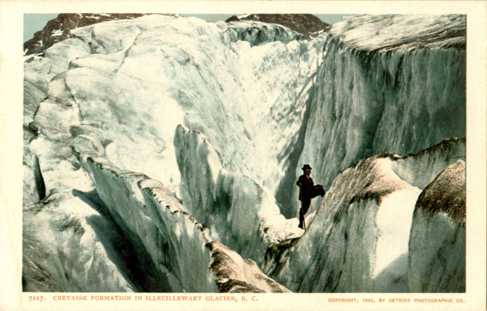 CANADA - CIRCA 1906: Postcard view of a man standing on giant crevasses in the glacier ice. (Photo by Lake County Museum/Getty Images)
