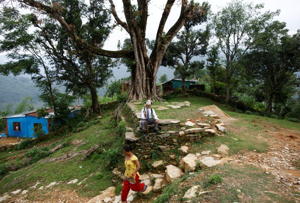 Durga Kami, 68, who is studying in the tenth grade at Shree Kala Bhairab Higher Secondary School, takes a rest as he walks to school in Syangja, Nepal, June 5, 2016. REUTERS/Navesh Chitrakar. SEARCH "DURGA KAMI" FOR THIS STORY. SEARCH "THE WIDER IMAGE" FOR ALL STORIES