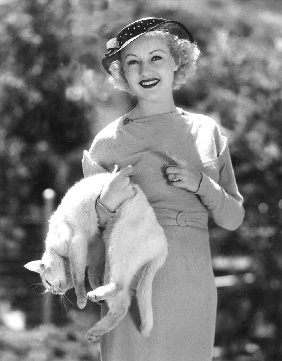Whitey shows Betty Grable how he can "play dead", 1935. (KEYSTONE/Everett Collection/) IM BILD / BILDSEITE LIEBEN MICH MEINE KATZEN BUND 23.7. TAGI 26.7.