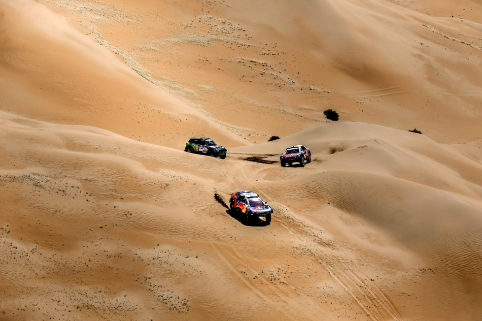 Mini team's Yazeed Mohamed al-Rhaji trails Peugeot team's Stephane Peterhansel and Cyril Despres during the 14th special stage of the Silkway rally in Inner Mongolia's Gobi desert near Wuhai. 130 competitors are racing over 10,734 kilometres crossing three countries and two continents from Moscow to Beijing. / AFP PHOTO / POOL / Bastien BAUDIN