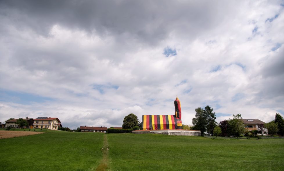 epa05410211 The church of Saint Coloman is covered in foil in the colours black, red and gold in the context of a woodworm pest control in Kirchseeon, Germany, 6 July 2016. The vermin are elimiated by a certain gas underneath the sealed foil. EPA/SVEN HOPPE