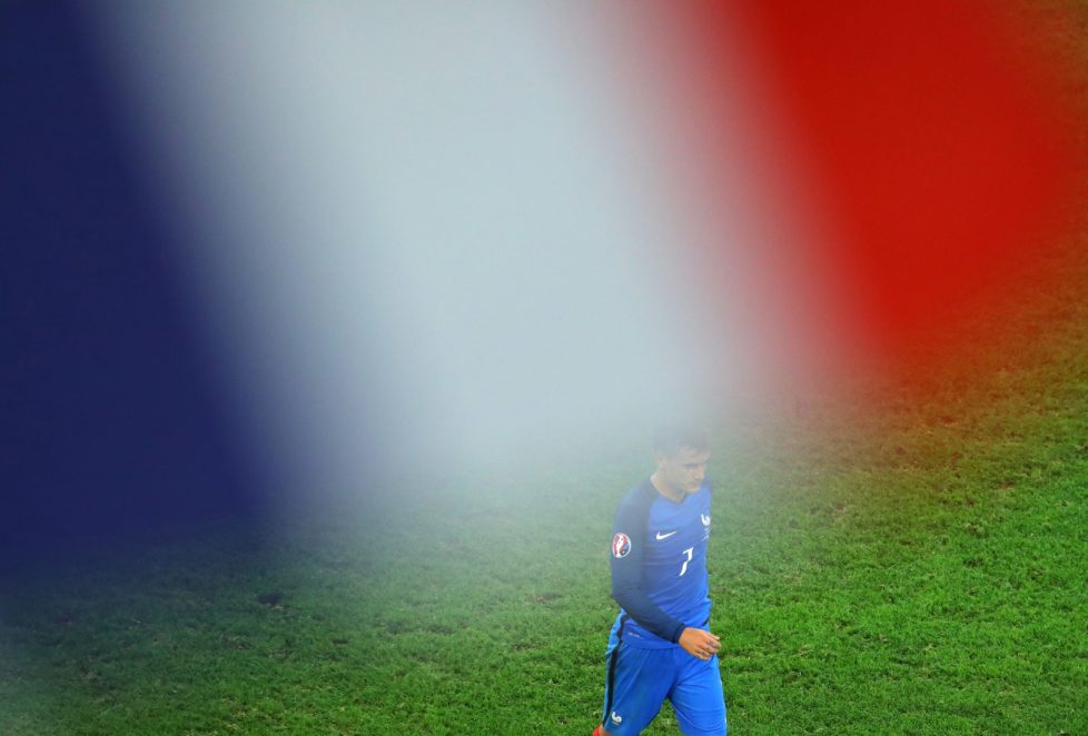 France's Antoine Griezmann is seen through a French flag waved by a spectator as he celebrates after scoring the opening goal during the Euro 2016 semifinal soccer match between Germany and France, at the Velodrome stadium in Marseille, France, Thursday, July 7, 2016. (AP Photo/Thibault Camus)
