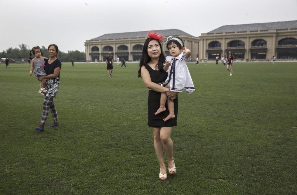 TIANJIN, CHINA - JULY 16: A Chinese woman walks across the field with their children during a break in an intervarsity tournament match at the Tianjin Goldin Metropolitan Polo Club on July 16, 2016 in Tianjin, China. China's rising affluence has nurtured growing interest in polo and other past-times regarded as noble or prestigious by the country's elite. Clubs and international-size polo fields have been built in various cities including Beijing and Shanghai, and on the outskirts of Tianjin, where membership at the exclusive Goldin Metropolitan, China's largest polo club, is by invitation-only and fees can be significant for polo team owners. Increasingly, wealthy Chinese parents are choosing polo and other equestrian activities for their children as a way to bolster their credentials for admission to top-tier universities in the United States and the United Kingdom. While the so-called "sport of kings" became a mainstay in Hong Kong during the era of British rule, polo is a relatively new sport to mainland China. Professional polo players are frequently flown in from countries such as New Zealand and Argentina in order to field competitive matches. Many of the polo clubs in China are tied to luxury real estate developments. (Photo by Kevin Frayer/Getty Images)