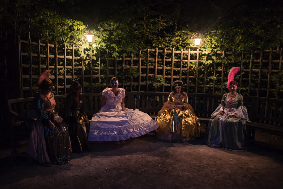 Costumed guests sit in the gardens of the Versailles castle before the Great Masked Bal, in Versailles, west of Paris, Saturday, June 27, 2015. On the occasion of the tercentenary of King Louis XIVs death, who died on Sept.1, 1715, a fountains show and a costumed ball took place in the castle.(AP Photo/Kamil Zihnioglu)