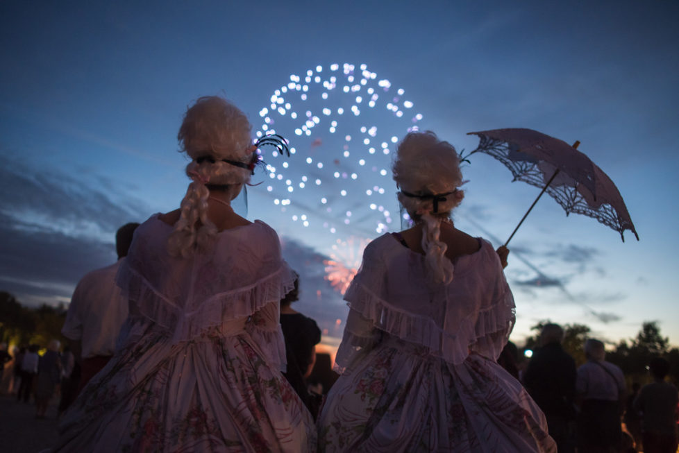 Costumed guests watch fireworks in the gardens of the Versailles castle before the Great Masked Bal, in Versailles, west of Paris, Saturday, June 27, 2015. On the occasion of the tercentenary of King Louis XIVs death, who died on Sept.1, 1715, a fountains show and a costumed ball took place in the castle.(AP Photo/Kamil Zihnioglu)