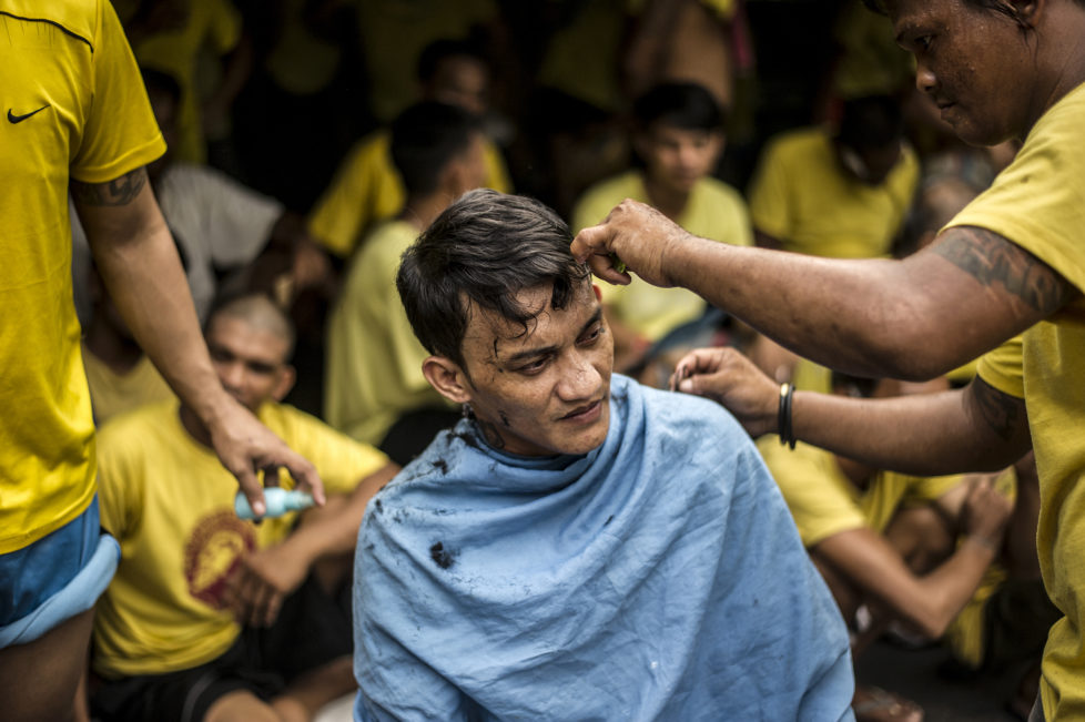 An inmate gets a haircut inside the Quezon City Jail in Manila in this picture taken on July 18, 2016. There are 3,800 inmates at the jail, which was built six decades ago to house 800, and they engage in a relentless contest for space. Men take turns to sleep on the cracked cement floor of an open-air basketball court, the steps of staircases, underneath beds and hammocks made out of old blankets. / AFP PHOTO / NOEL CELIS / TO GO WITH AFP STORY: Philippines-politics-crime-jails, FOCUS by Ayee Macaraig