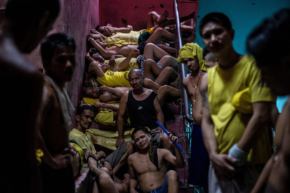 Inmates sleep on the steps of a ladder inside the Quezon City jail at night in Manila in this picture taken on July 18, 2016. There are 3,800 inmates at the jail, which was built six decades ago to house 800, and they engage in a relentless contest for space. Men take turns to sleep on the cracked cement floor of an open-air basketball court, the steps of staircases, underneath beds and hammocks made out of old blankets. / AFP / NOEL CELIS / TO GO WITH AFP STORY: Philippines-politics-crime-jails, FOCUS by Ayee Macaraig (Photo credit should read NOEL CELIS/AFP/Getty Images)