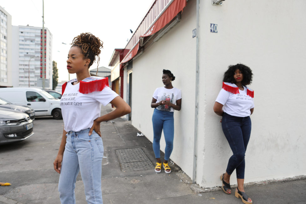 Designer Aisse N'diaye (R) and friends Sandrine Alcan (L) and Virginie Ehonian (C) wear T-shirts from N'diaye's brand Afrikanista in Clichy-sous-bois, France, August 26, 2016. N'diaye grew up in Clichy-sous-bois, where her parents currently live. REUTERS/Joe Penney SEARCH "CREATIVE BANLIEUE" FOR THIS STORY. SEARCH "WIDER IMAGE" FOR ALL STORIES. THE IMAGES SHOULD ONLY BE USED TOGETHER WITH THE STORY - NO STAND-ALONE USES.