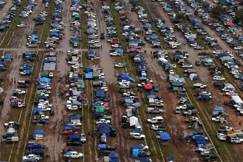 Campers trudge through mud among hundreds of ute vehicles in a paddock in this aerial picture at the Deni Ute Muster in Deniliquin, New South Wales, Australia, October 1, 2016. REUTERS/Jason Reed SEARCH "UTE CULTURE" FOR THIS STORY. SEARCH "THE WIDER IMAGE" FOR ALL STORIES.