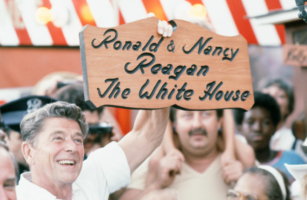 During his presidential campaign, American politician (and future US President) Ronald Reagan (1911 - 2004) holds up a personalized wooden sign at the Michigan State Fair, Ionia, Michigan, August 8, 1980. The sign reads 'Ronald & Nancy Reagan; The White House' with the lettering burning into a piece of cut wood. (Photo Robert R. McElroy/Getty Images)