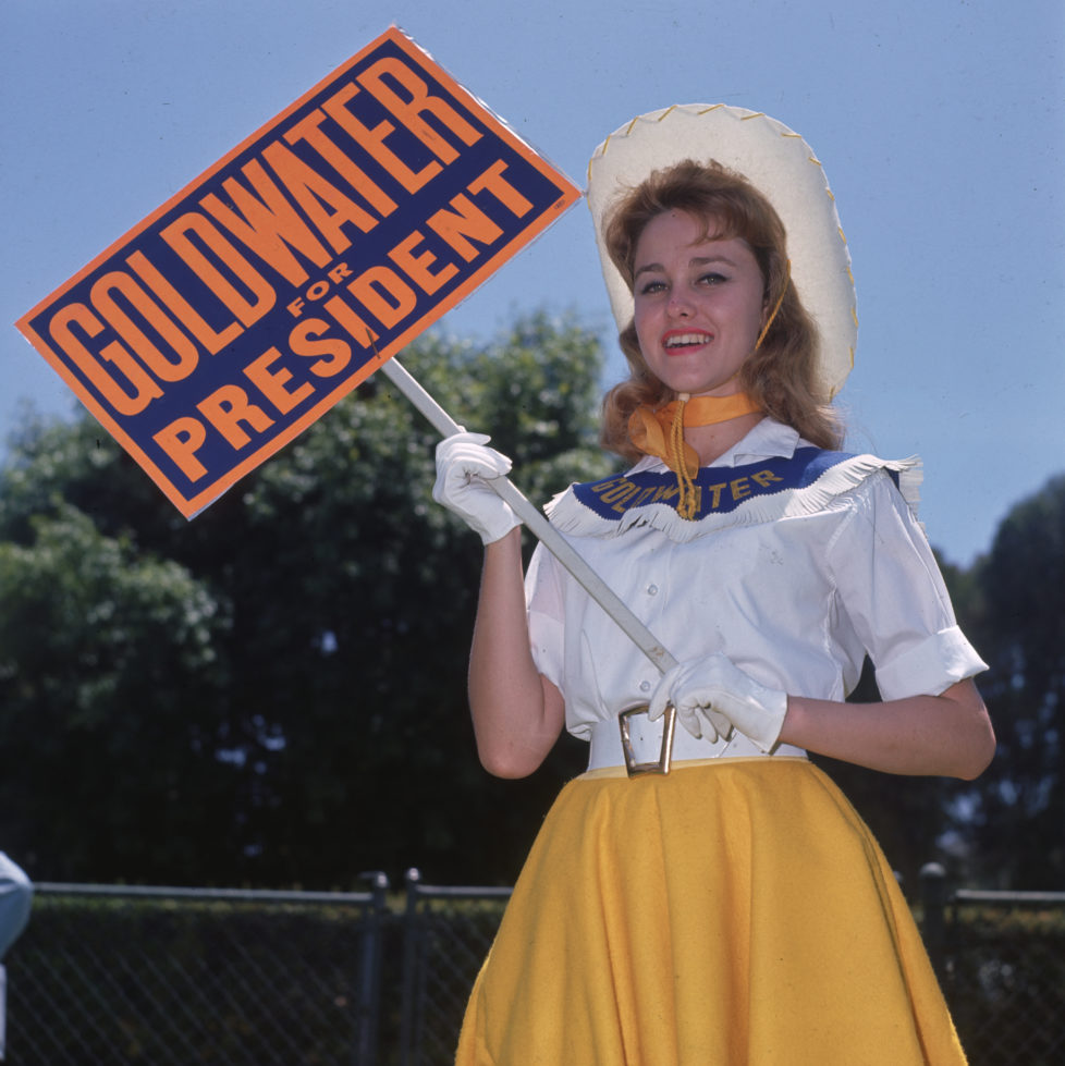 July 1964: A Goldwater girl campaigning for Barry Goldwater, the Republican candidate for the Presidential election, in Sherman Oaks, California. Aged between 18 and 25, the Goldwater Girls will be continuing their support for Goldwater at the Republican Convention in San Francisco. (Photo by Miller/BIPs/Getty Images)