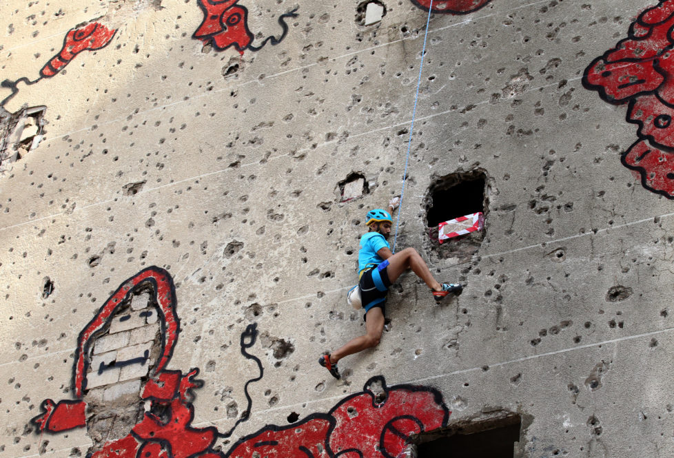 A competitor climbs the hole-ridden facade of Beirut's al-Kamal building, which was severely damaged during the Lebanese civil war (1975-1990), during an urban climbing contest on November 12, 2016. The contestants will compete in three rounds in order to select the winner who has achieved the fastest possible time to reaching the top. / AFP PHOTO / ANWAR AMRO