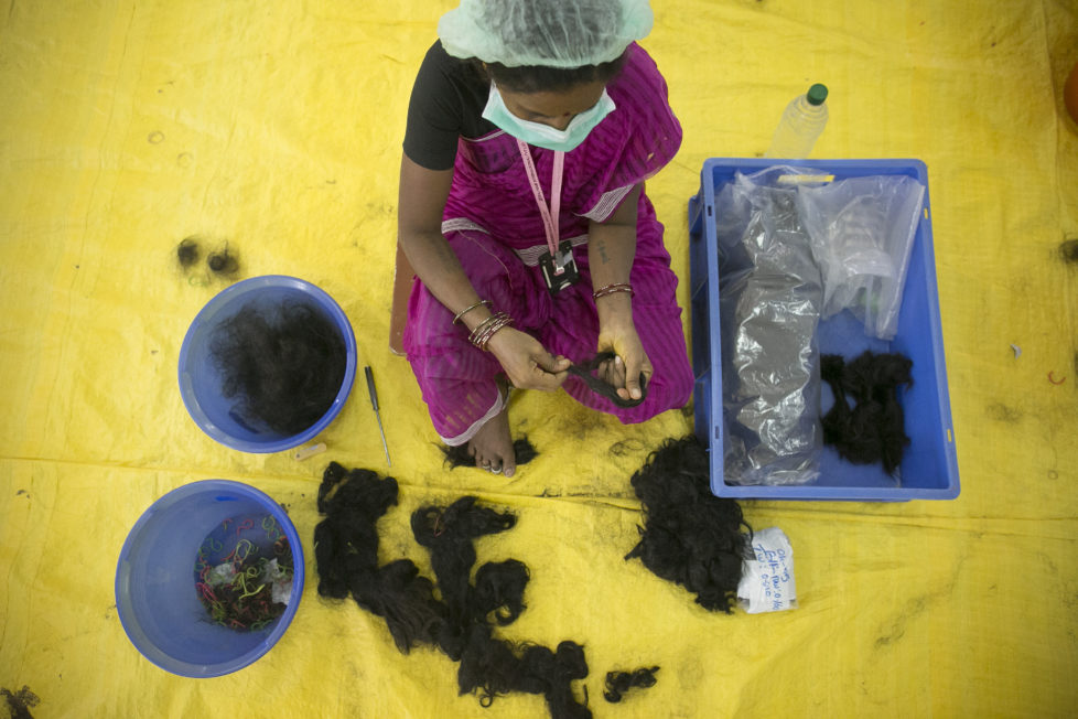 CHENNAI, INDIA - NOVEMBER 11: A worker processes hair at Raj Hair International November 11, 2016 in Thiruttani, India. Raj Hair International donates wigs to cancer patients in India and also exports hair products, including weaves and wigs, to 56 countries. All of the hair they export comes from Tamil Nadu, 1/4 of which is temple hair and the rest comes from comb waste that people sell. They estimate that it takes 1 full month to make one wig by hand. The process of shaving ones hair and donating it to the Gods is known as tonsuring. It is common for Hindu believers to tonsure their hair at a temple as a young child, and also to celebrate a wish coming true, such as the birth of a baby or the curing of an illness. The "temple hair", as it's known, is then auctioned off to a processing plant and then sold as pricey wigs and weaves in the US, Europe and Africa. (Photo by Allison Joyce/Getty Images)