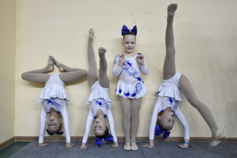 Members of a cheerleading team warm-up during the Russian Cheerleading Championship of students in Moscow on November 20, 2016. / AFP PHOTO / Natalia KOLESNIKOVA