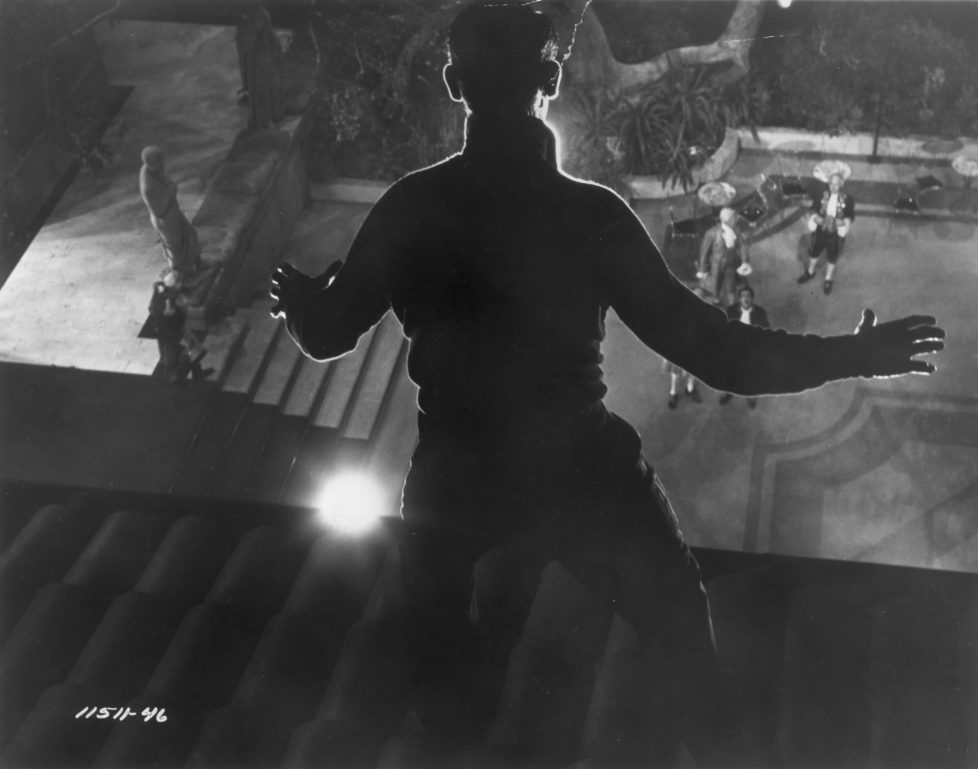 1955: Thief Cary Grant (1904 - 1986) stands frozen in the light as he is spied on the roof in a scene from Hitchcock's film 'To Catch A Thief'. (Photo by Hulton Archive/Getty Images)