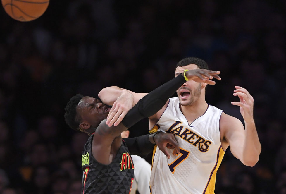 Los Angeles Lakers forward Larry Nance Jr., right, passes as Atlanta Hawks guard Dennis Schroder, of Germany, defends during the second half of an NBA basketball game, Sunday, Nov. 27, 2016, in Los Angeles. The Lakers won 109-94. (AP Photo/Mark J. Terrill)